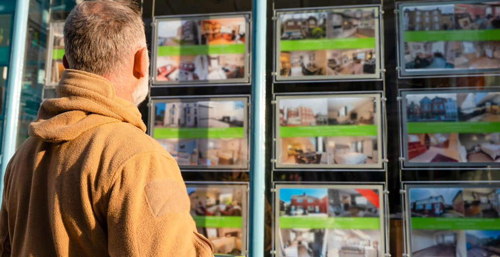 Gestionnaire immobilier consultant un planning d'occupation locative sur ordinateur dans une agence de location saisonnière à Hossegor